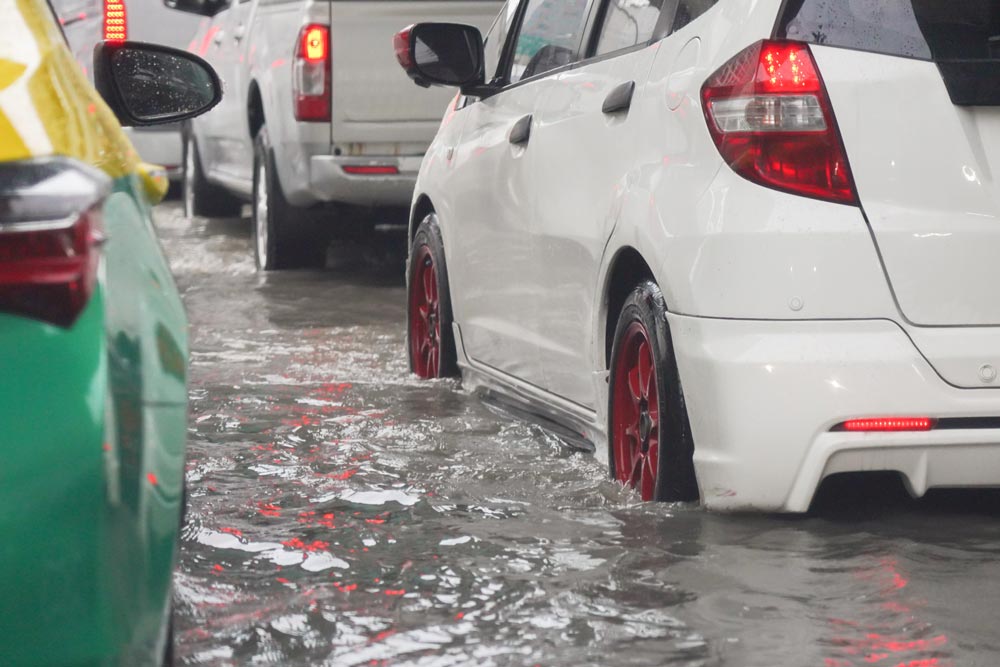 รถติดบนถนนขณะที่ฝนตกหนักจนน้ำท่วม
